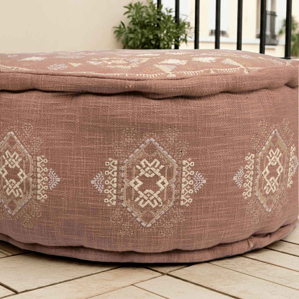 Terra Cotta Embroidered Moroccan Pouf showcasing intricate embroidery and rich earthy hue on a round pouf.
