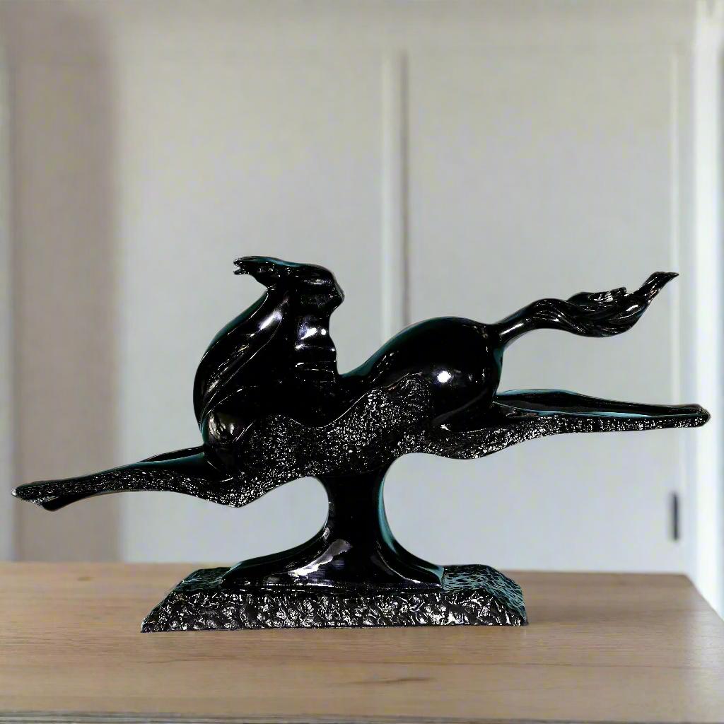 Black horse sculpture on a wooden surface with a neutral background
