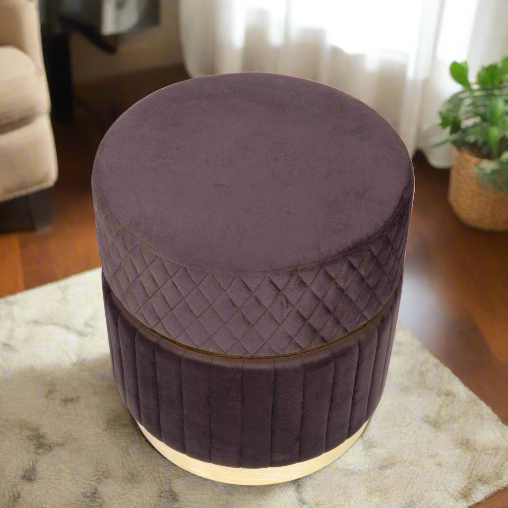 Round purple ottoman with quilted design on a rug in a room setting.