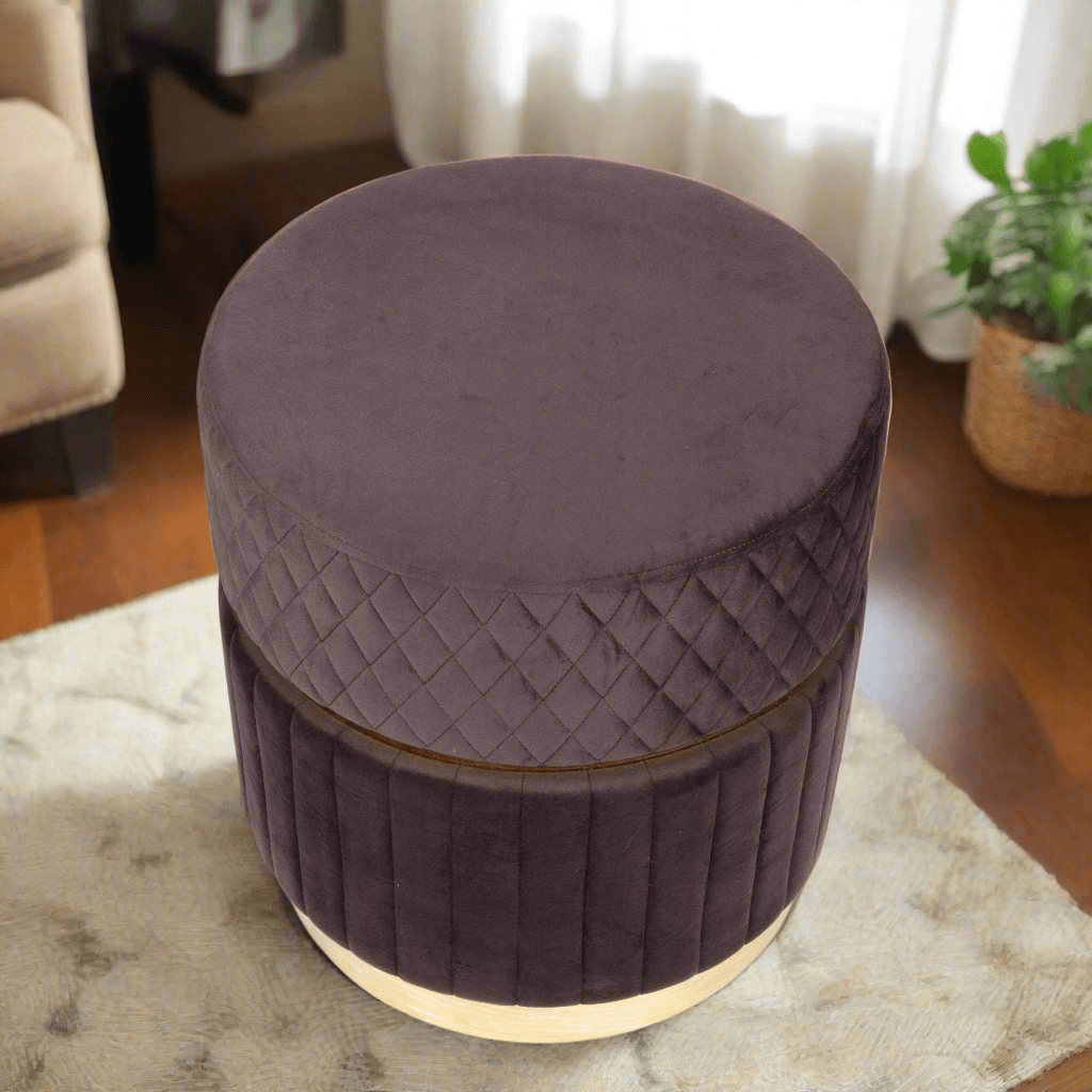 Round purple ottoman with quilted design on a rug in a room setting.
