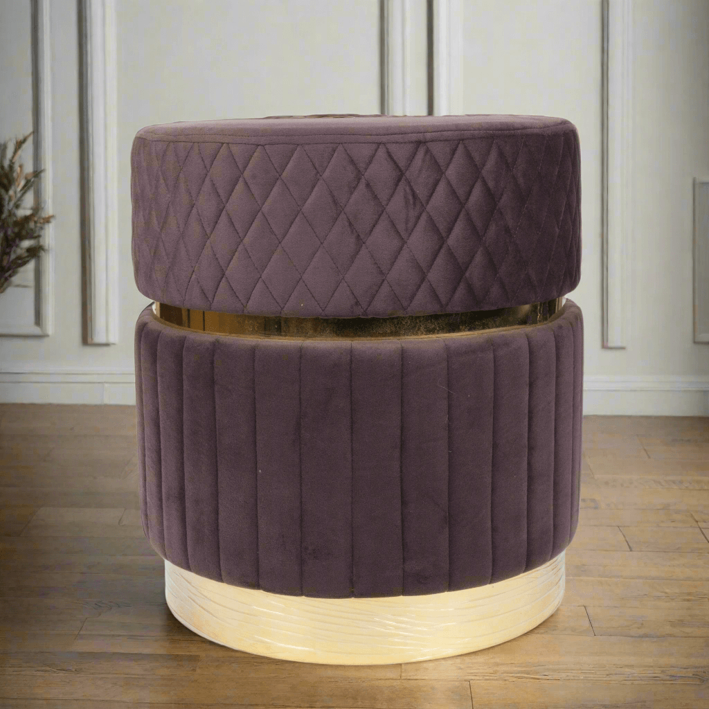 Purple quilted ottoman on a wooden floor with a neutral wall background
