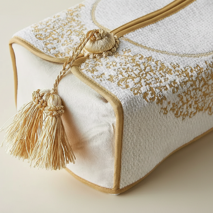 Decorative pillow with gold embroidery and tassels on a beige background