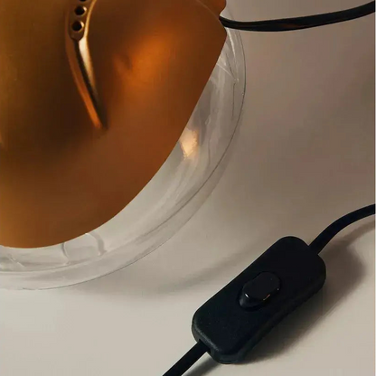 Black electronic device with a cable next to a transparent container on a light background