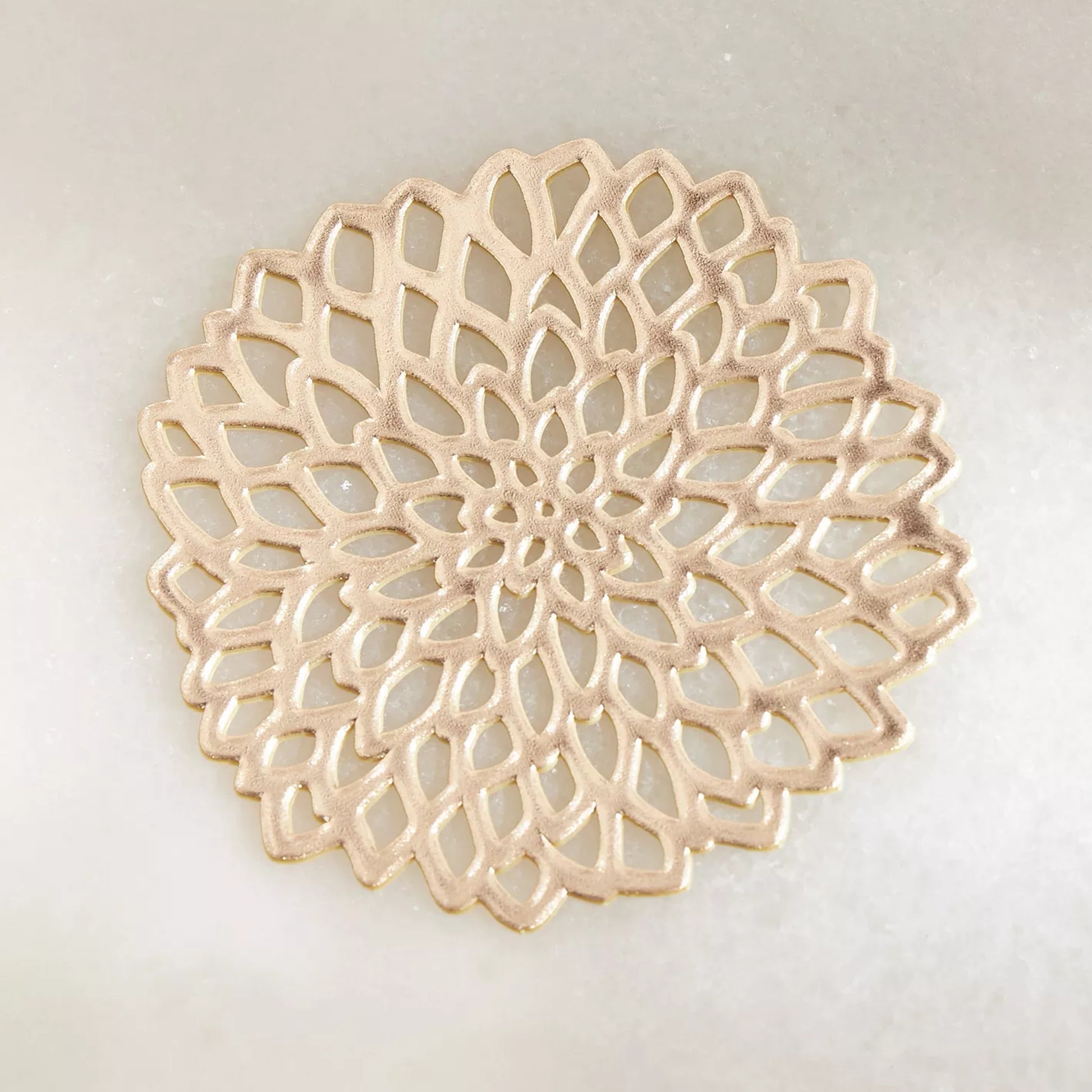Decorative beige plate with intricate lace-like pattern on a light gray background