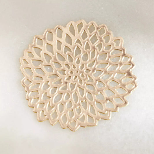 Decorative beige plate with intricate lace-like pattern on a light gray background