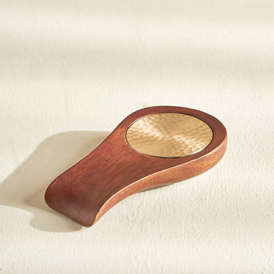 Wooden and aluminum-handled object on a beige background
