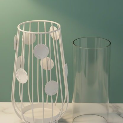 Decorative white metal lamp with circular patterns next to a clear glass vase on a light surface.