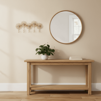 Set of five gold floral wall hooks on a beige wall.