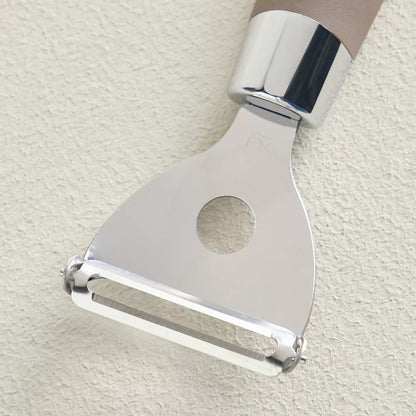 Metallic peeler on a light beige background