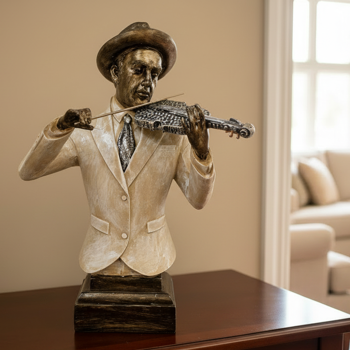 Bronze statue of a man playing a violin on a wooden table in a living room.