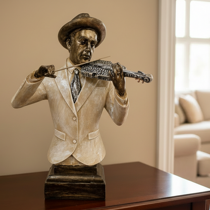 Bronze statue of a man playing a violin on a wooden table in a living room.