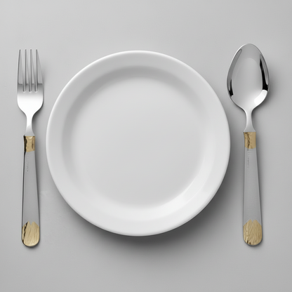 White plate with silver fork and spoon on a gray background