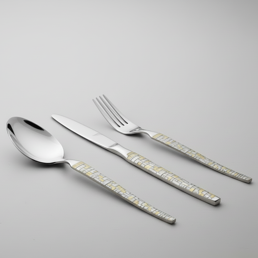 Set of silver cutlery with decorative handles on a gray background