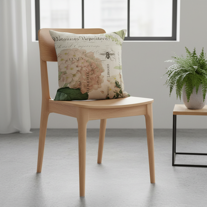 Wooden chair with a decorative pillow featuring floral and bee design in a room with a window and plant.