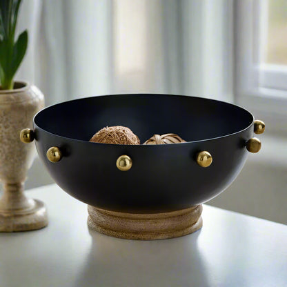 Black bowl with gold accents on a wooden surface