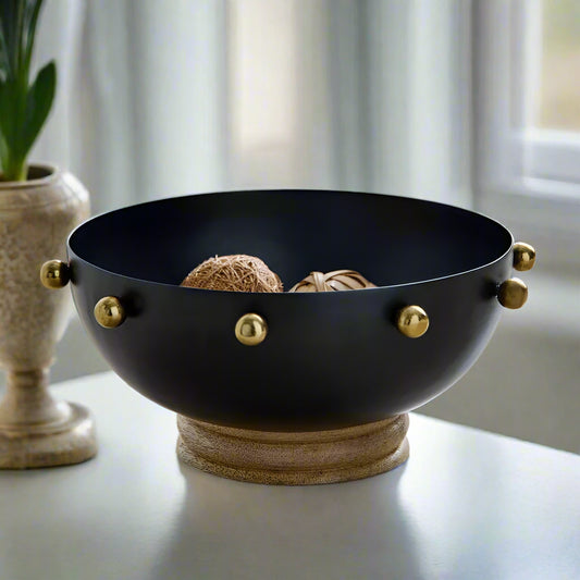 Black bowl with gold accents on a wooden surface