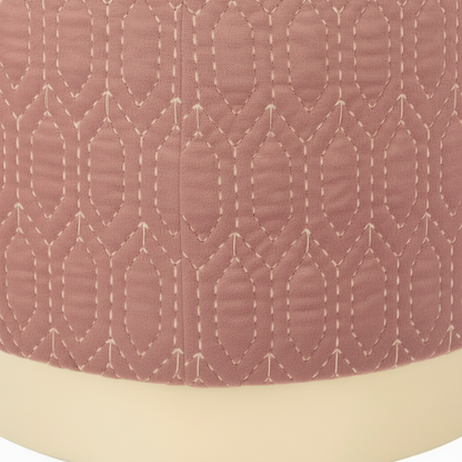 Close-up of a quilted fabric with a geometric pattern on a pink background