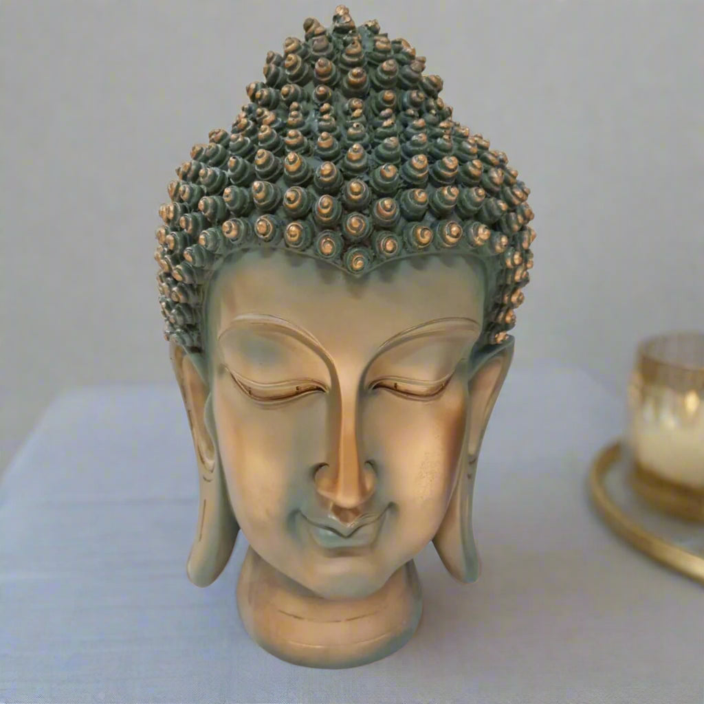 Bronze Buddha head sculpture on a white background