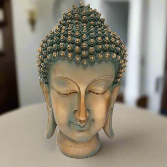 Bronze Buddha head sculpture on a white background