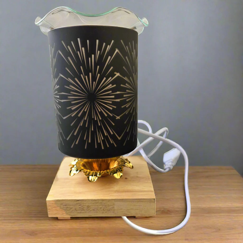 Decorative lamp with black shade and gold design on a wooden base, plugged into a white cable.