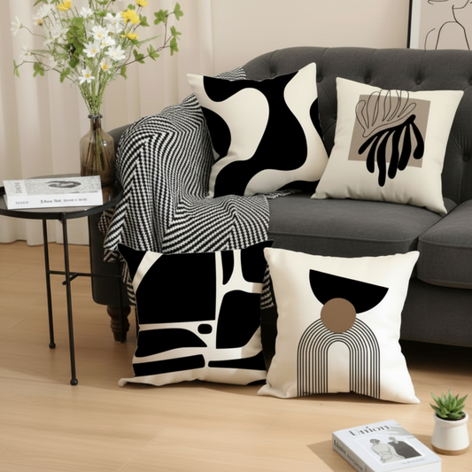 Decorative pillows with abstract patterns on a gray sofa in a living room setting.