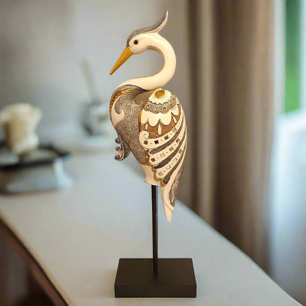 Decorative heron sculpture on a stand in a home setting