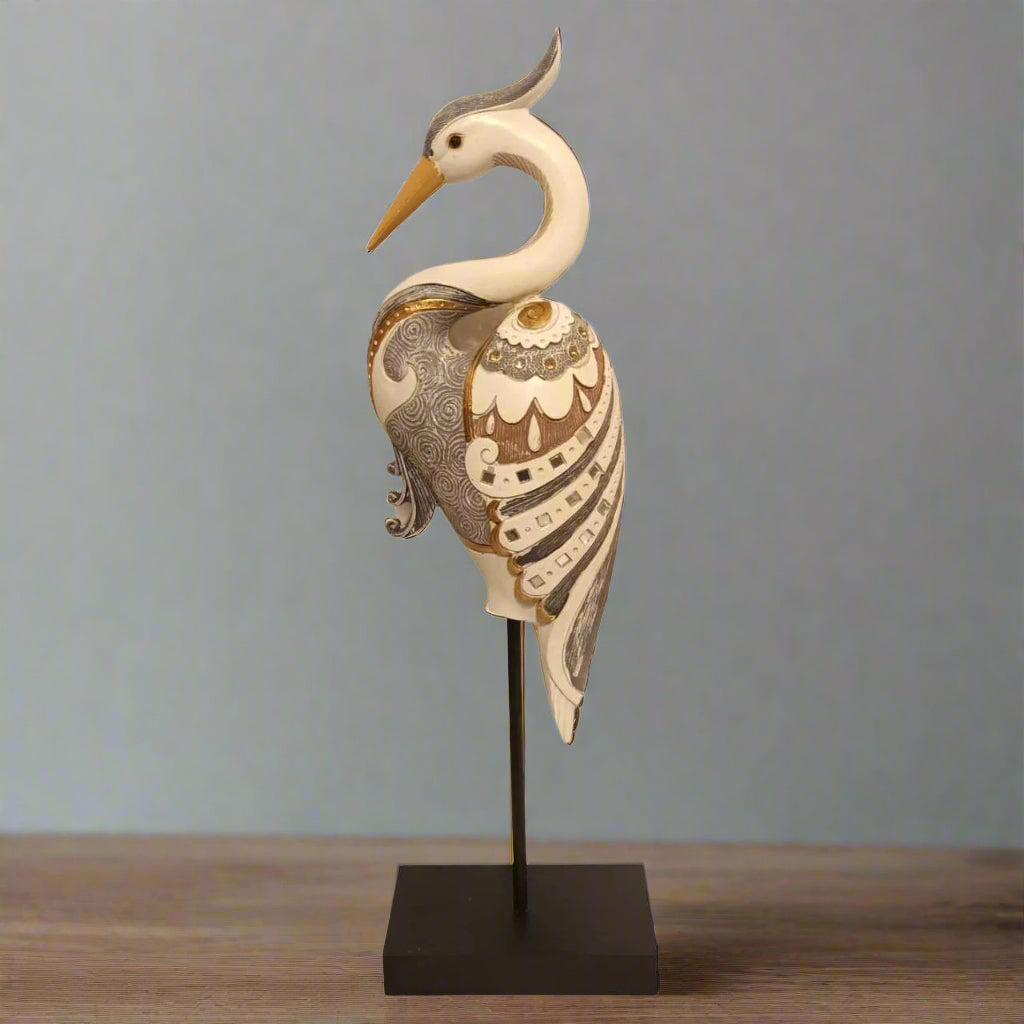 Decorative heron sculpture on a stand with intricate patterns