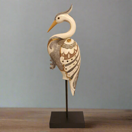 Decorative heron sculpture on a stand with intricate patterns