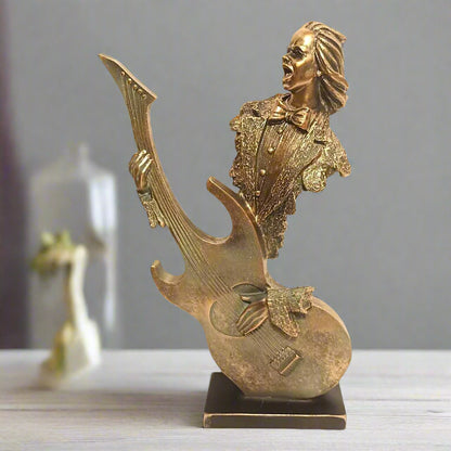 Gold figurine of a musician with a guitar on a gray background