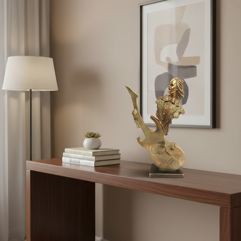 Decorative gold sculpture on a wooden console table with a lamp and framed abstract art in the background.