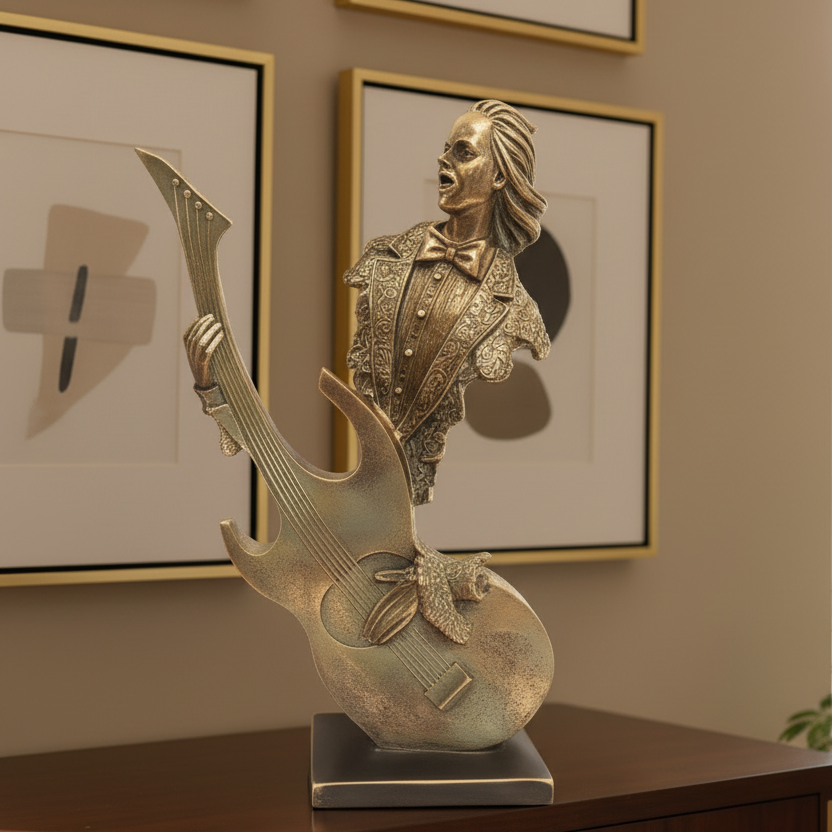 Decorative sculpture of a person playing an electric guitar on a table with framed pictures in the background.