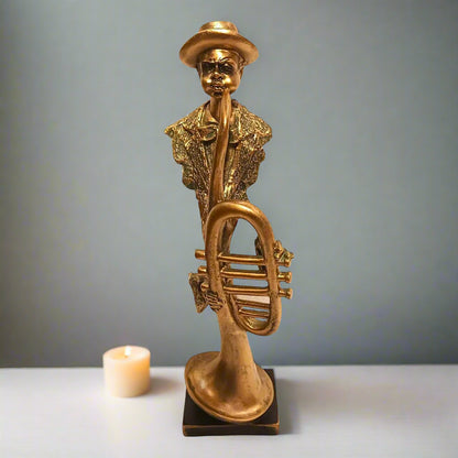 Gold statue of a person playing a horn on a gray background