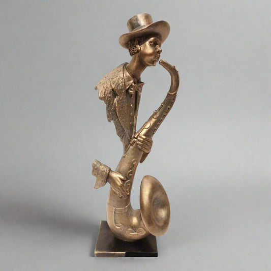 A bronze-toned sculpture of a saxophone player with a hat and a stylized design.