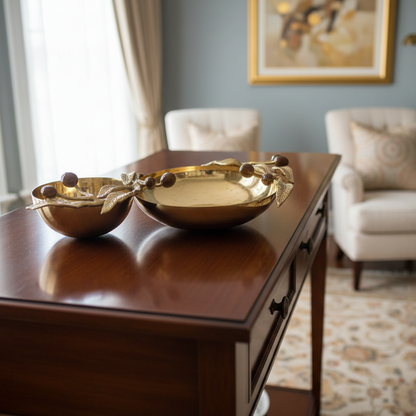 Gold decorative dish with leaf and berry design on a gray background