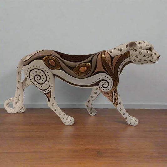 Decorative animal sculpture on a wooden floor with a plain background