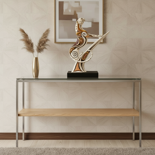 Modern console table with decorative sculpture and vase against a neutral wall.