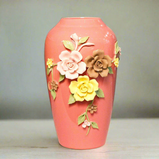 Pink vase with floral decorations on a teal background