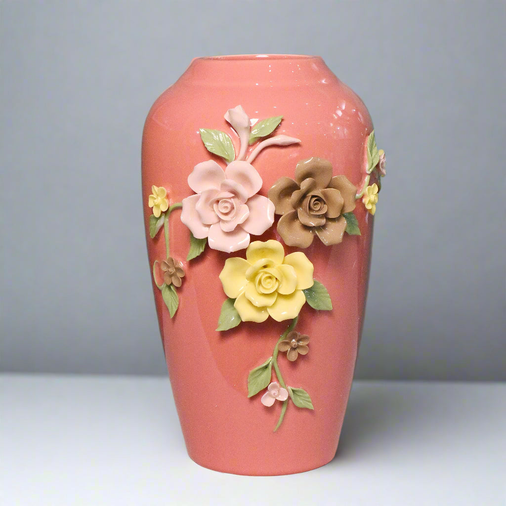Pink vase with floral decorations on a teal background
