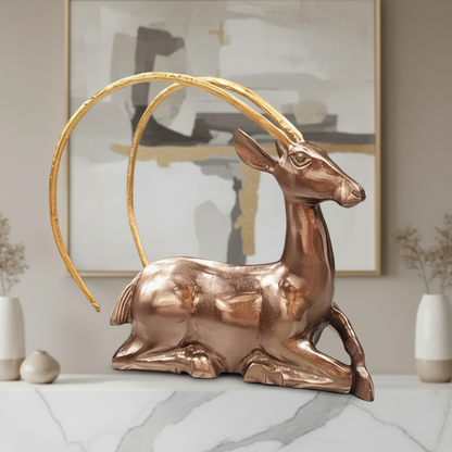 Bronze deer sculpture with a gold arch in a decorative setting