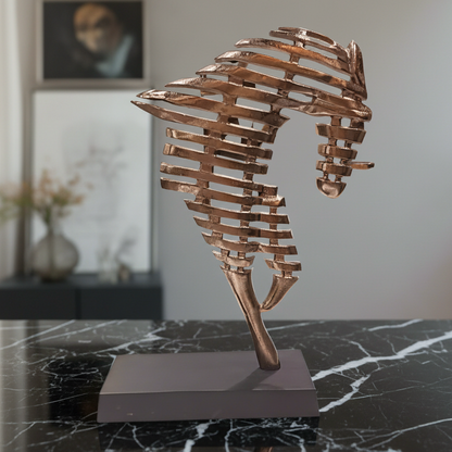 Bronze seahorse sculpture on a dark marble surface with a blurred indoor background
