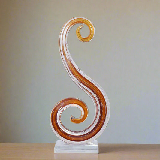 Decorative glass sculpture with a swirling design on a white background