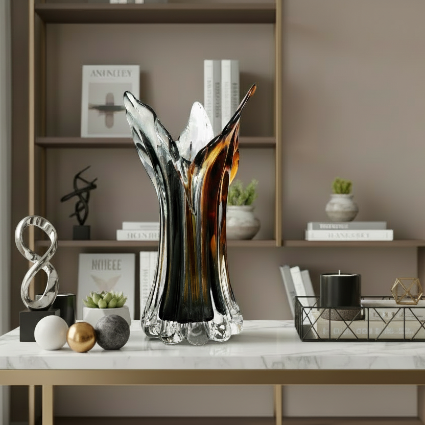 Decorative glass vase on a marble surface with a bookshelf in the background