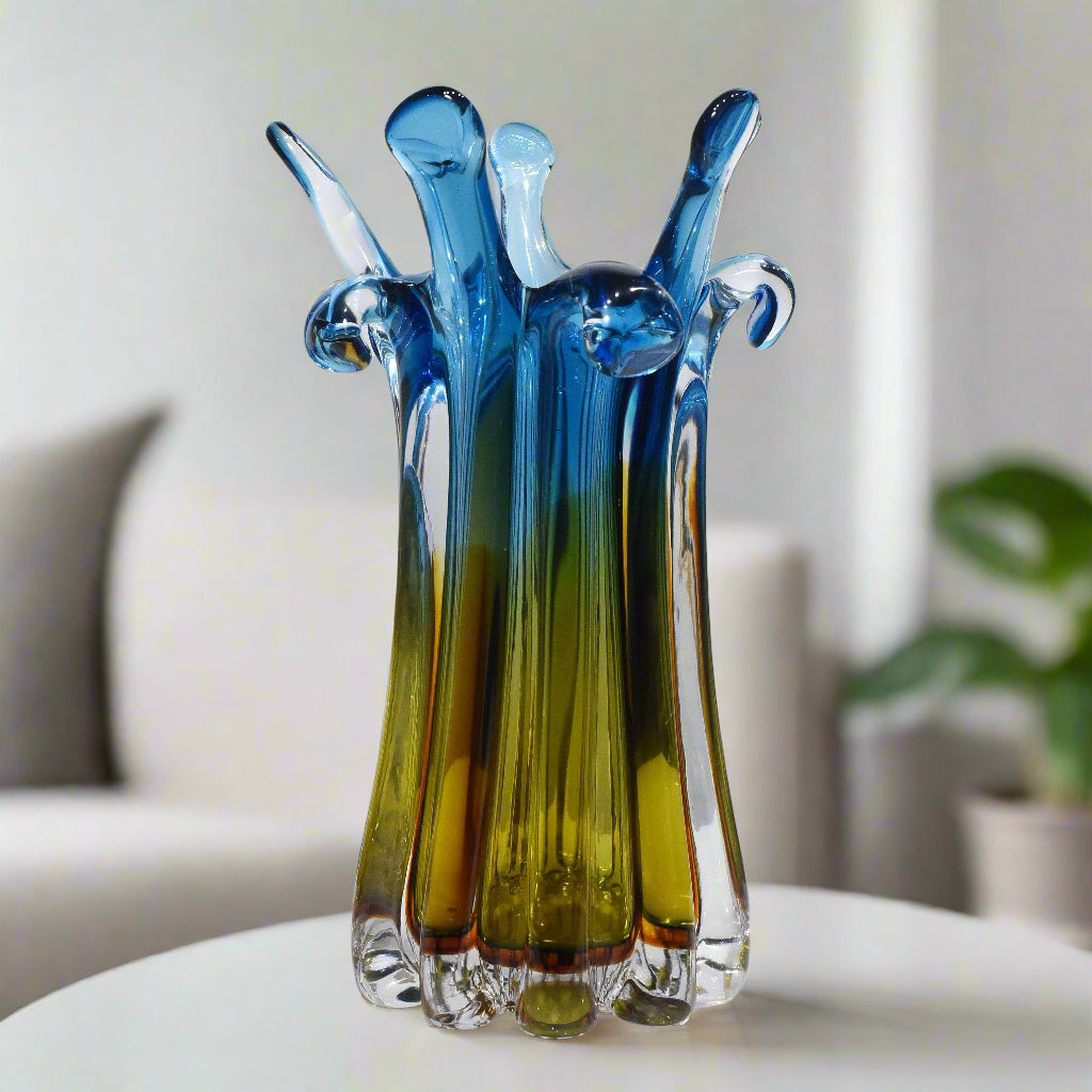 Colorful glass sculpture on a white surface with a light gray background