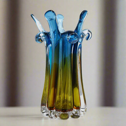 Colorful glass sculpture on a white surface with a light gray background