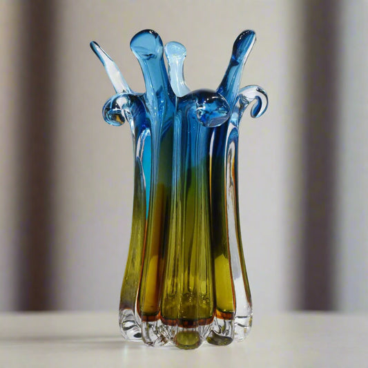 Colorful glass sculpture on a white surface with a light gray background