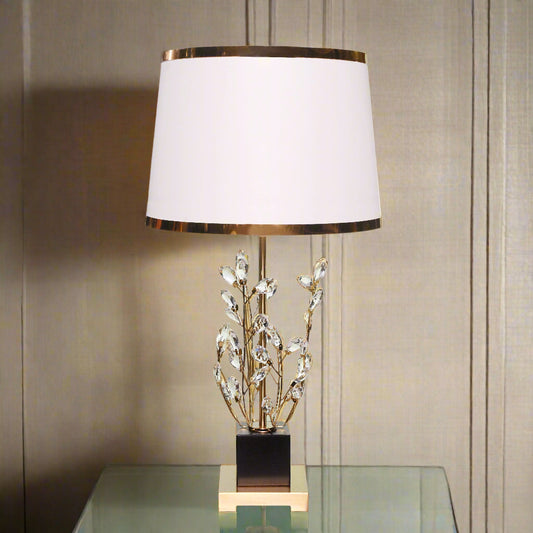 Decorative table lamp with a white shade and decorative base on a light background