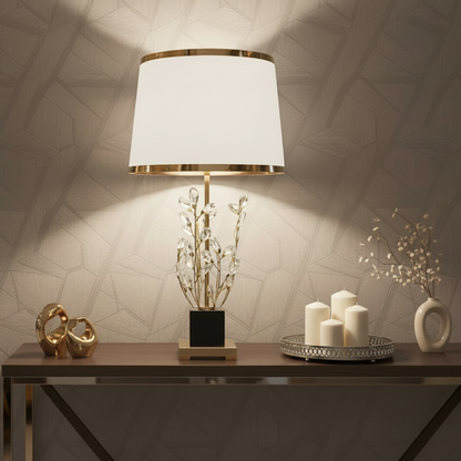 Decorative table setting with a lamp, candles, and decorative items against a textured wall.