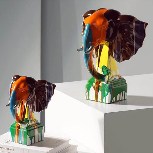 Colorful elephant sculptures on a white surface with a gray background