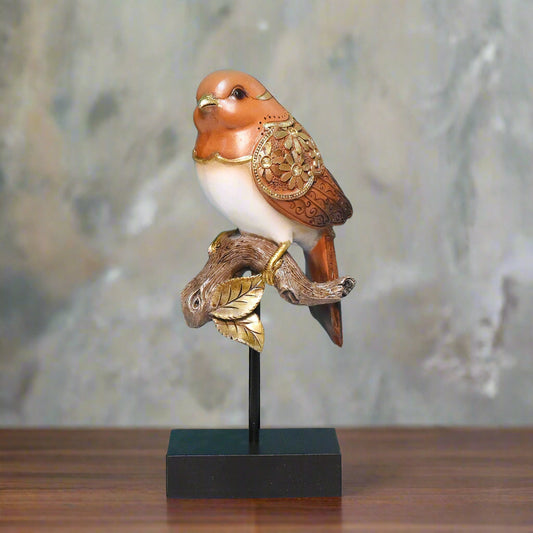 Decorative bird figurine with gold accents on a stand against a teal wall.