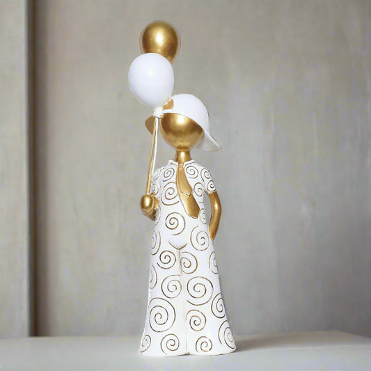 Decorative figurine with gold and white elements on a plain background